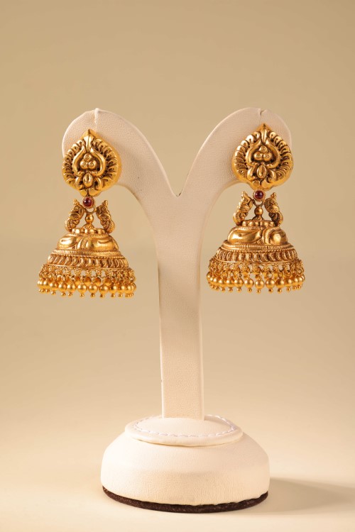 Konikkara antique-gold jhumka earrings on a display stand